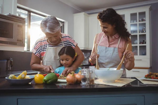 Avó ensinando neta para cortar legumes — Fotografia de Stock