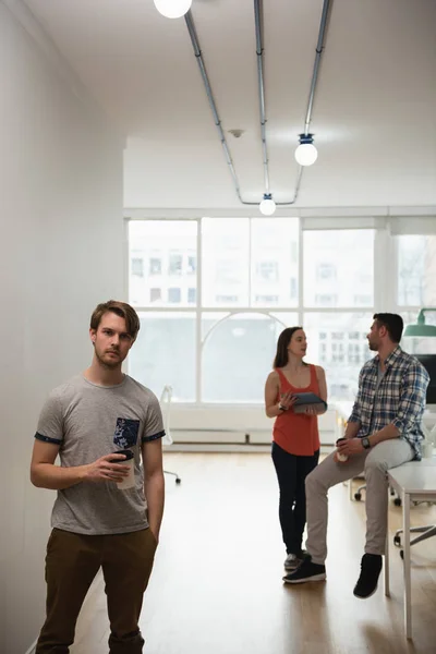 Executive holding coffee while colleague discussing — Stock Photo, Image