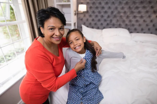 Grootmoeder helpen meisje jas dragen — Stockfoto