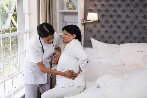 Verpleegkundige meewerkende patiënten lijden met rugpijn — Stockfoto