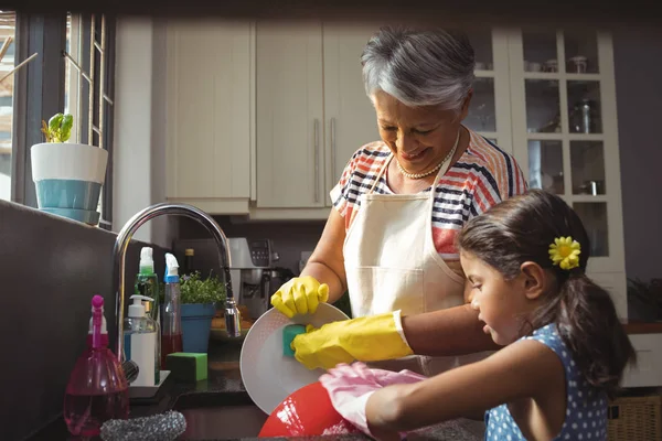 Abuela y nieta lavando utensilios —  Fotos de Stock