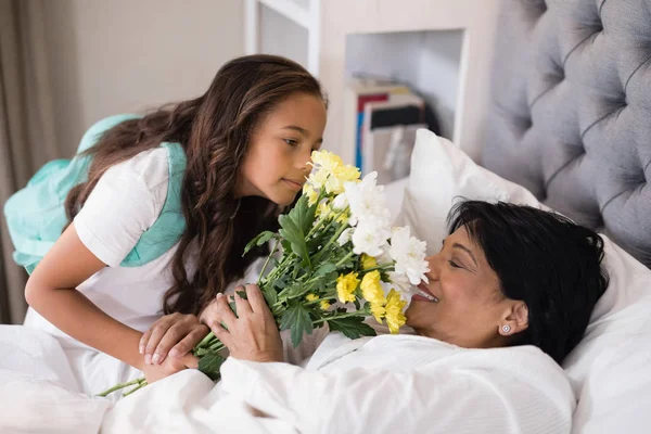 病気の祖母に花束を与える少女 — ストック写真