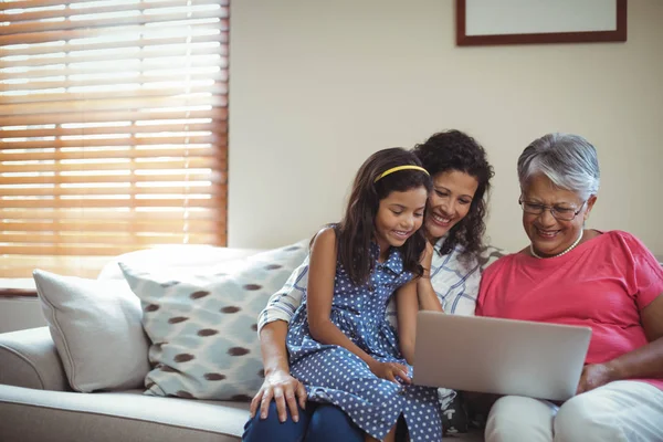 Familie nutzt Laptop im Wohnzimmer — Stockfoto