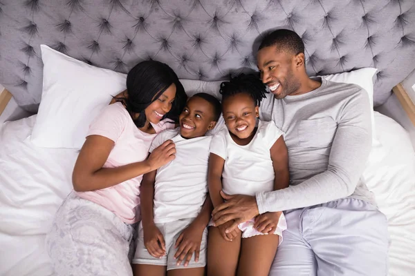 Familie samen liggend op bed thuis — Stockfoto