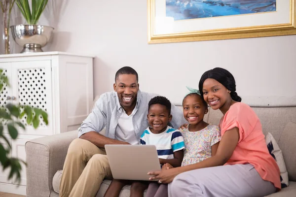 Familie nutzt Laptop auf Sofa zu Hause — Stockfoto