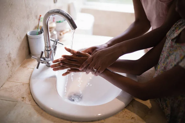Moeder en dochter wassen van de handen bij de wastafel — Stockfoto