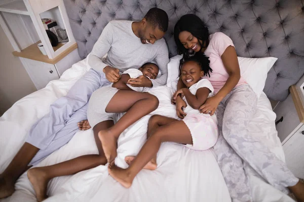 Familia disfrutando juntos en la cama —  Fotos de Stock