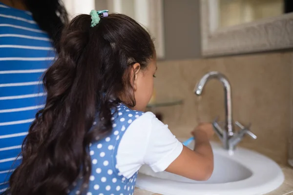 Chica con madre cepillarse los dientes — Foto de Stock