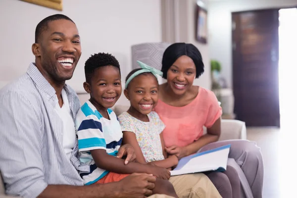 Familia alegre con revista — Foto de Stock