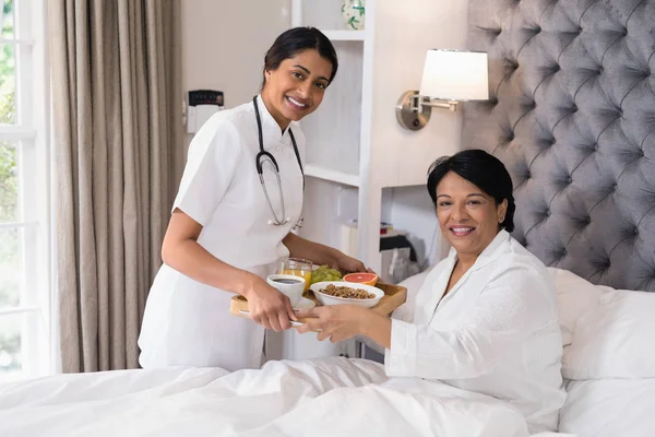 Enfermera sirviendo desayuno a paciente — Foto de Stock