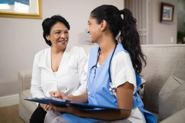 Doctor with patient sitting on sofa — Stock Photo, Image