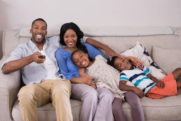 Família feliz desfrutando de televisão em casa — Fotografia de Stock