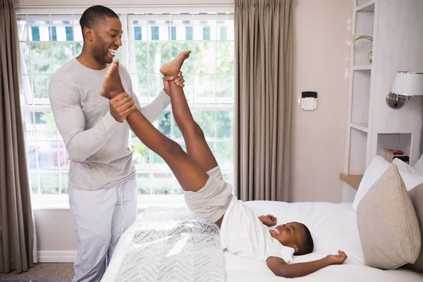 Alegre padre jugando con hijo en el dormitorio —  Fotos de Stock