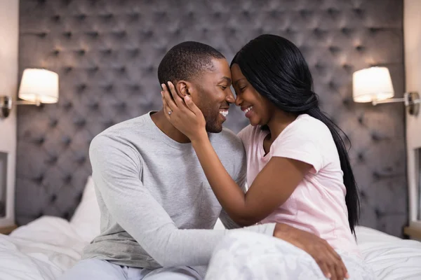 Young couple embracing in bedroom — Stock Photo, Image