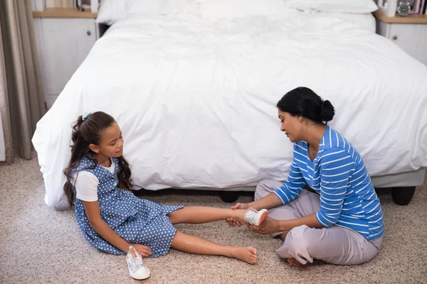 Mother helping daughter to wear shoe — Stock Photo, Image