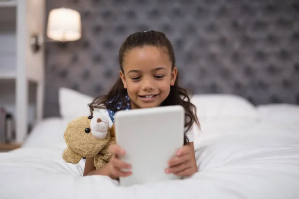 Κορίτσι που χρησιμοποιούν tablet ενώ ξαπλωμένος στο κρεβάτι — Φωτογραφία Αρχείου
