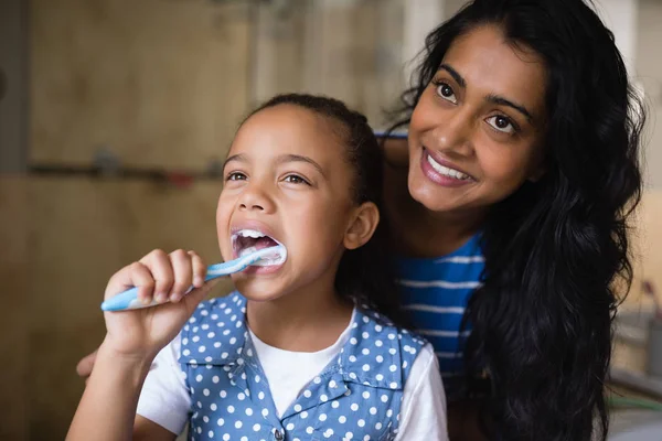 Madre in piedi da figlia lavarsi i denti — Foto Stock