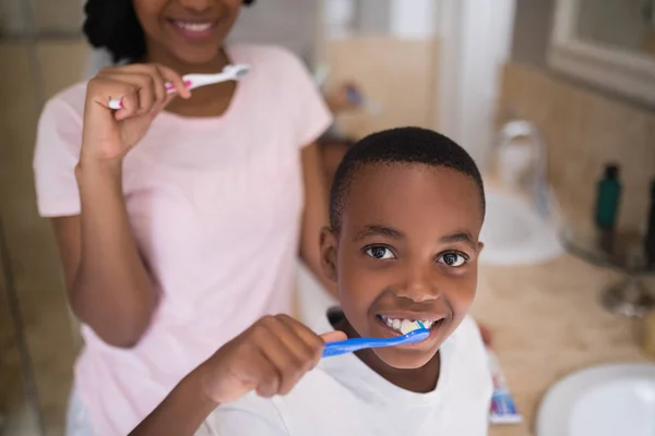 Boy with mother brushing teeth at home — Stock Photo, Image
