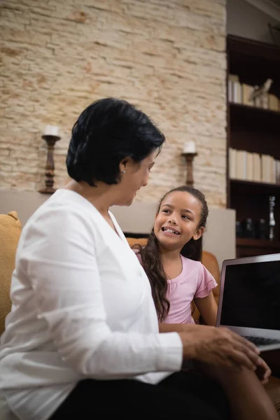 Chica con abuela sosteniendo portátil —  Fotos de Stock