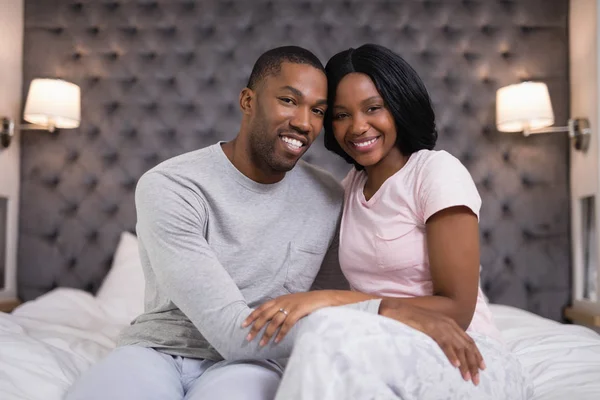 Young couple sitting on bed at home — Stock Photo, Image