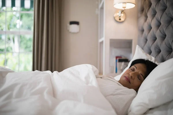 Rijpe vrouw op bed thuis slapen — Stockfoto