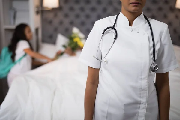 Enfermeira de pé com o paciente na cama — Fotografia de Stock