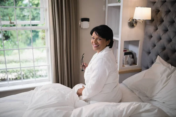 Kobieta siedzi w sypialni podświetlane — Zdjęcie stockowe