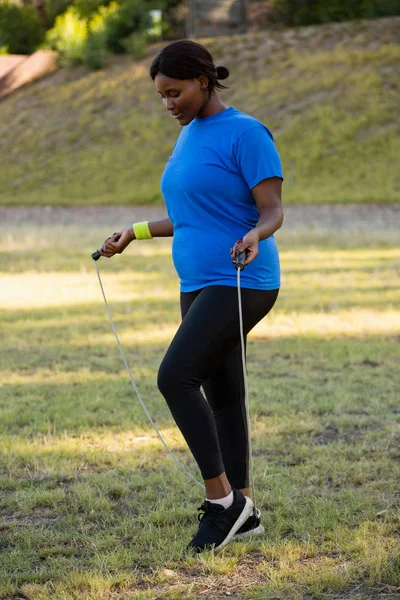 Fit vrouw springtouw in het park — Stockfoto