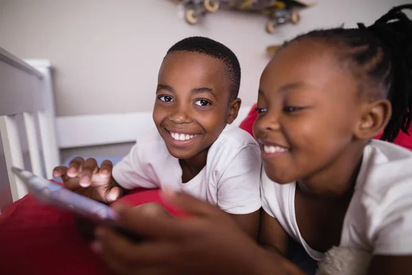 Frères et sœurs utilisant le téléphone mobile — Photo