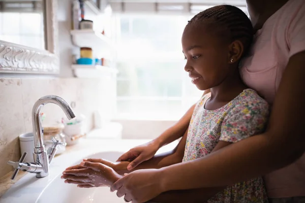 Madre che assiste la figlia mentre si lava le mani — Foto Stock