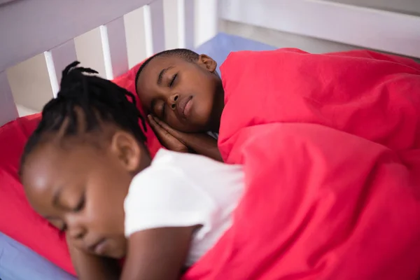 Broer en zus op bed thuis slapen — Stockfoto