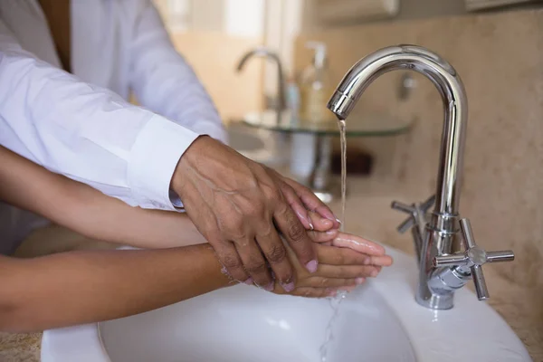 Granny helping girl while washing hands — Stock Photo, Image