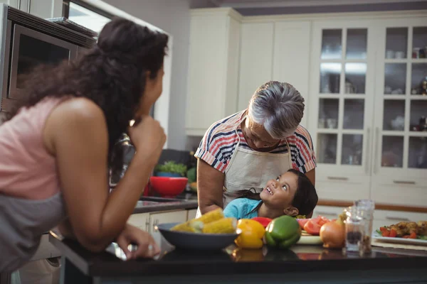Família interagindo uns com os outros na cozinha — Fotografia de Stock