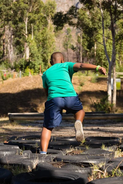 Хлопчик біжить за шинами — стокове фото