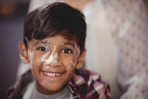 Niño sonriente con harina en la cara —  Fotos de Stock