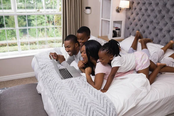 家族がベッドの上に横たわっている間オンライン ショッピング — ストック写真