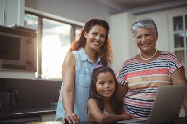 Familia feliz usando el portátil en la cocina —  Fotos de Stock