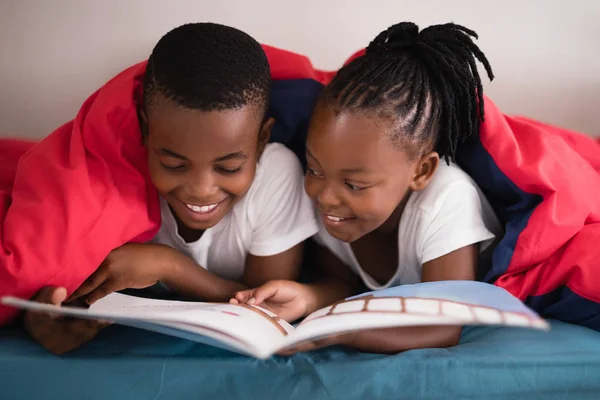Ler syskon läser bok — Stockfoto