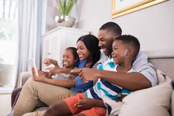 Семья с помощью планшета на диване — стоковое фото