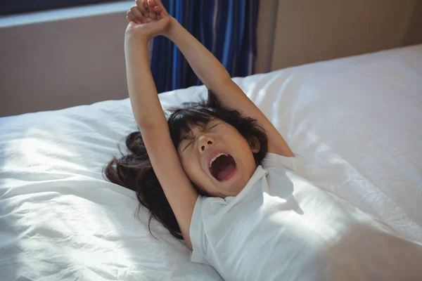 Girl yawning on bed in the bed room — Stock Photo, Image