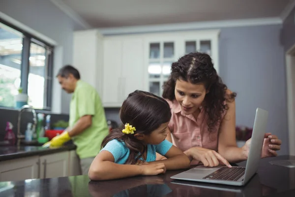 Madre e figlia utilizzando il computer portatile in cucina — Foto Stock