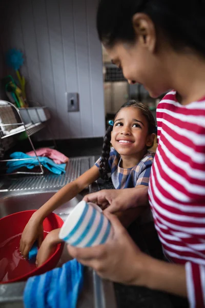 Mignonne fille aider sa mère dans la cuisine — Photo