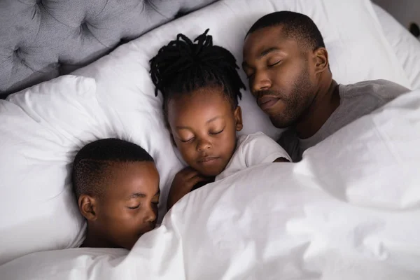 Babası ile birlikte yatakta uyuyan çocuk — Stok fotoğraf