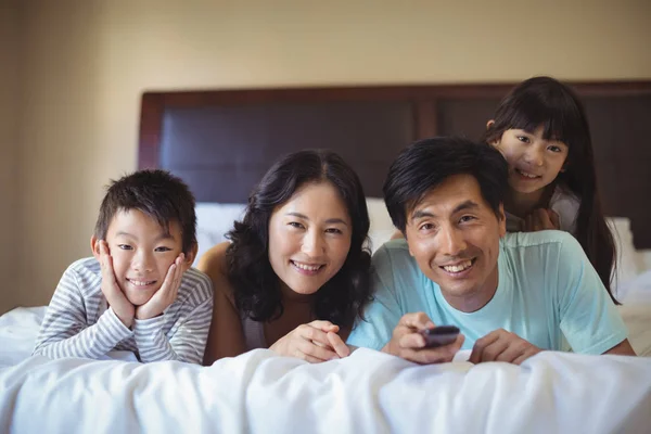 Familjen tittar på TV i sovrummet — Stockfoto