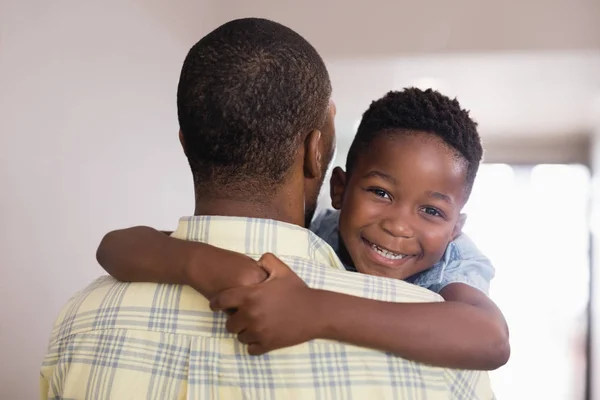 Boy embracing father at home — Stock Photo, Image