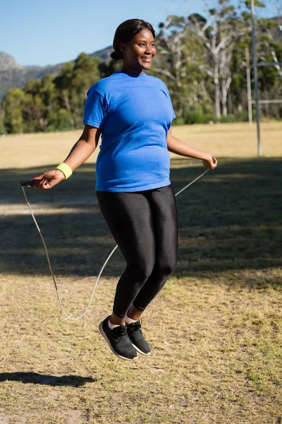 Fit vrouw springtouw in het park — Stockfoto