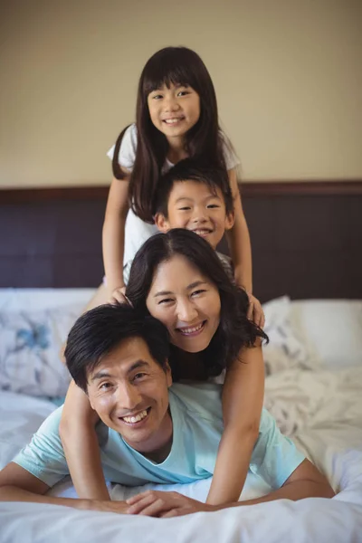 Família se divertindo na cama no quarto da cama — Fotografia de Stock