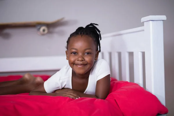 Chica sonriente acostada en la cama — Foto de Stock