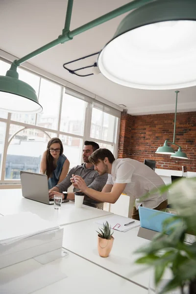 Ejecutivos discutiendo sobre portátil — Foto de Stock