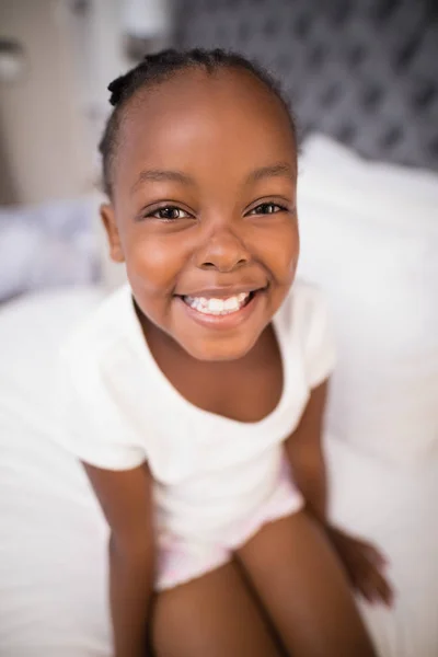 Sorrindo menina sentada na cama — Fotografia de Stock